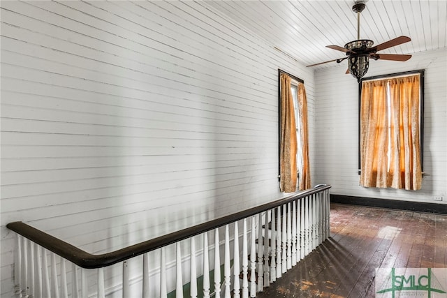 hallway with wooden walls, wood ceiling, and dark hardwood / wood-style floors