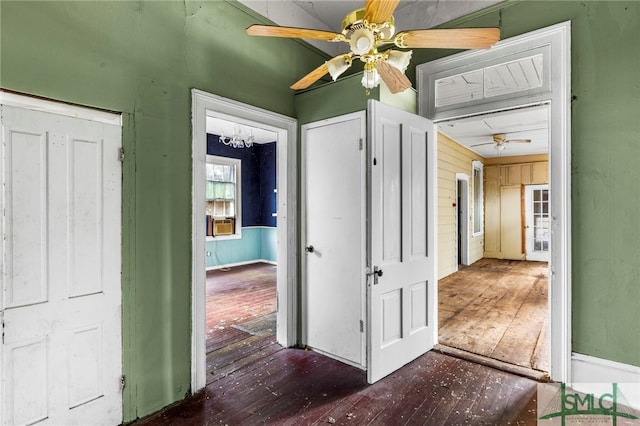 interior space featuring wood walls, ceiling fan, and dark hardwood / wood-style floors