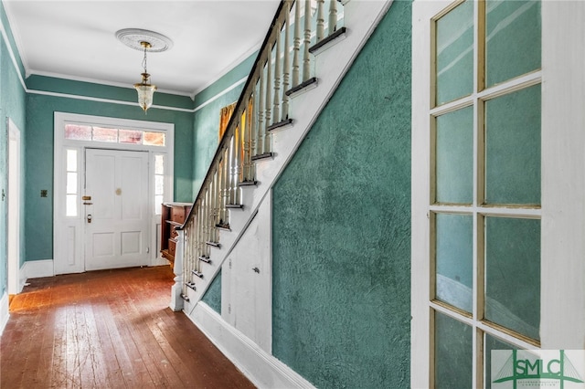 entryway featuring wood-type flooring and ornamental molding