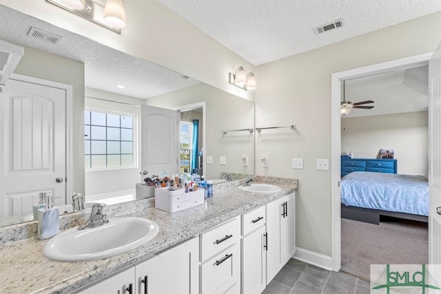 bathroom featuring tile patterned flooring, vanity, a textured ceiling, and ceiling fan