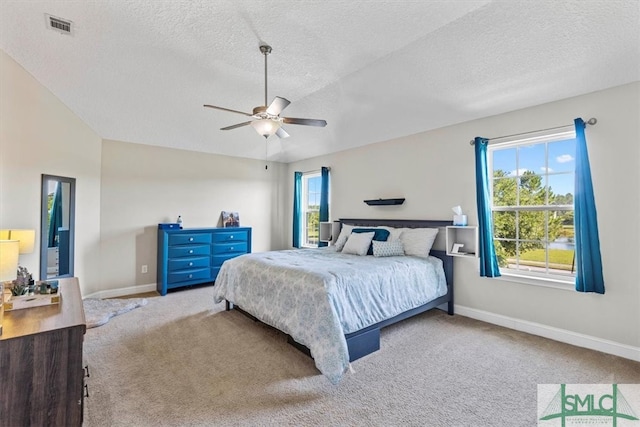 carpeted bedroom with a textured ceiling, lofted ceiling, and ceiling fan