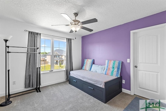 bedroom with a textured ceiling, light carpet, and ceiling fan