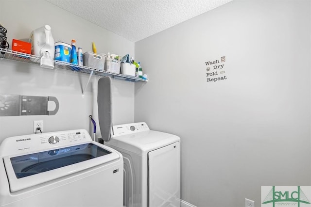 laundry room featuring a textured ceiling and washer and clothes dryer