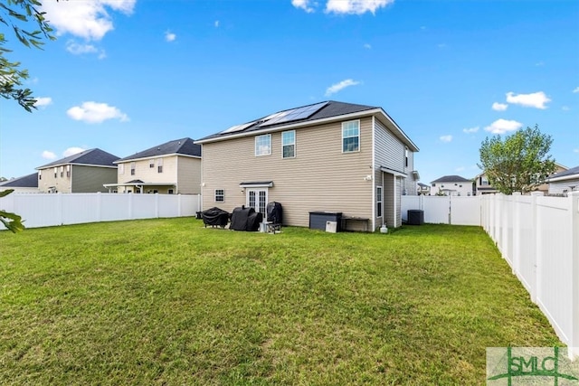 back of property with central air condition unit and a yard