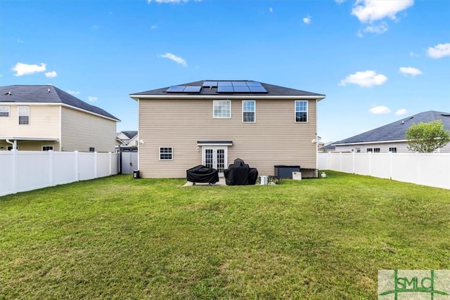 back of house featuring solar panels and a yard