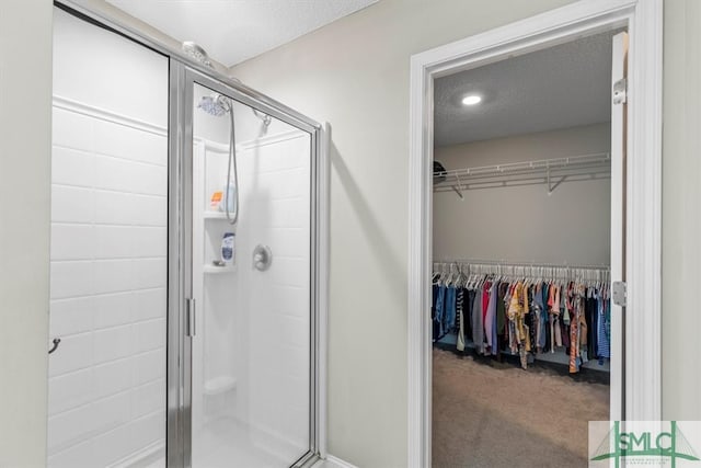 bathroom with a textured ceiling and a shower with shower door