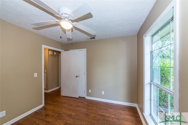 spare room with ceiling fan, dark hardwood / wood-style flooring, and a textured ceiling