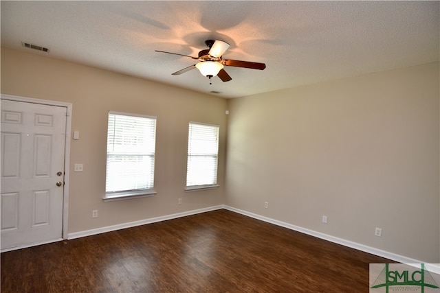 spare room featuring ceiling fan, a textured ceiling, and dark hardwood / wood-style flooring