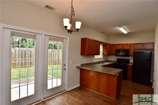 kitchen with black appliances, a chandelier, dark hardwood / wood-style flooring, pendant lighting, and kitchen peninsula