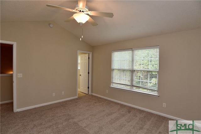 carpeted spare room featuring ceiling fan and vaulted ceiling