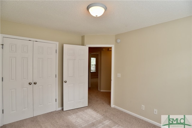 unfurnished bedroom with a textured ceiling, light carpet, and a closet