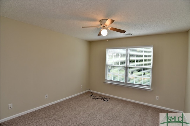 empty room with ceiling fan, a textured ceiling, and carpet