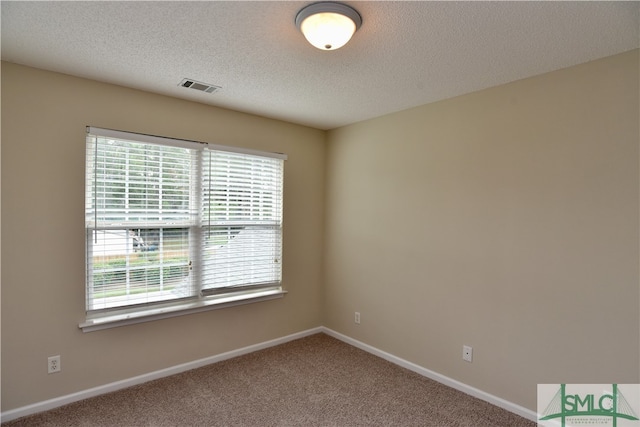 unfurnished room with a textured ceiling and carpet flooring