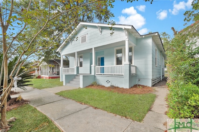 bungalow with a front yard and a porch