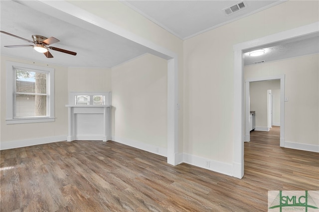 unfurnished living room featuring hardwood / wood-style floors, ceiling fan, and crown molding