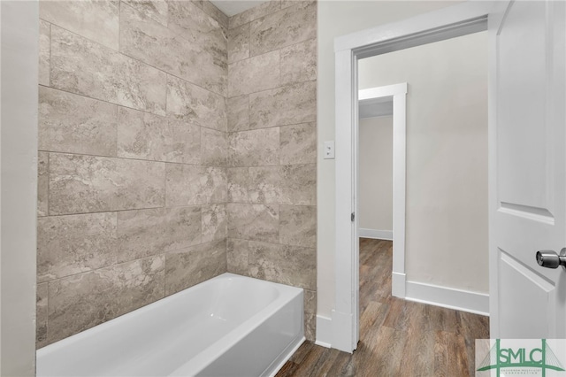 bathroom featuring hardwood / wood-style floors and tiled shower / bath