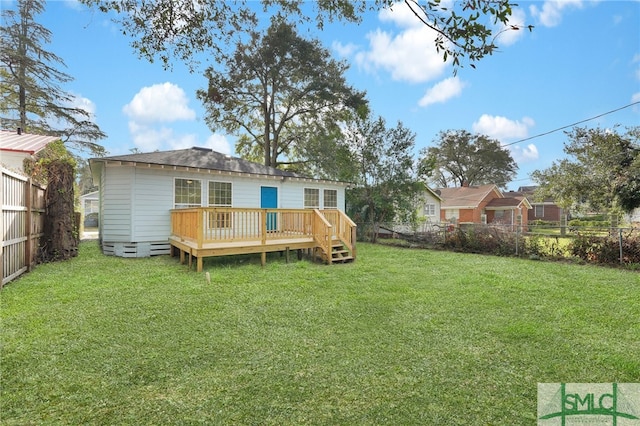 back of house featuring a lawn and a wooden deck