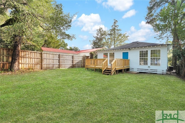 rear view of house featuring a lawn and a deck