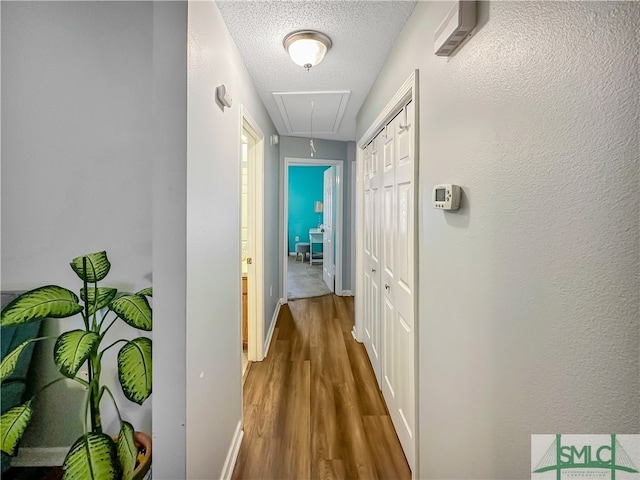 corridor with dark hardwood / wood-style flooring and a textured ceiling