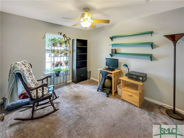 carpeted home office featuring a textured ceiling and ceiling fan