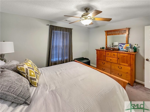 carpeted bedroom featuring a textured ceiling and ceiling fan