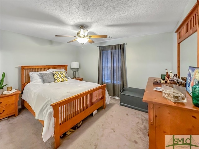 carpeted bedroom featuring a textured ceiling and ceiling fan