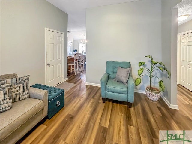 living area featuring hardwood / wood-style floors and a chandelier