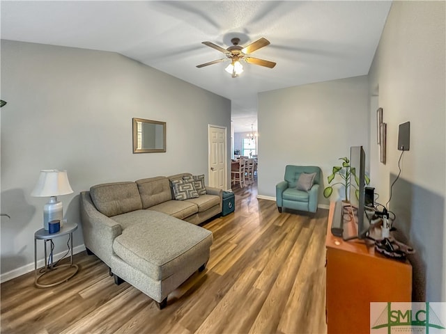 living room with vaulted ceiling, hardwood / wood-style flooring, and ceiling fan