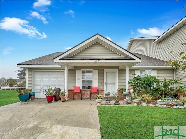 view of front of home with a front lawn, a garage, and covered porch