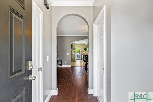 hall with dark wood-type flooring and ornamental molding