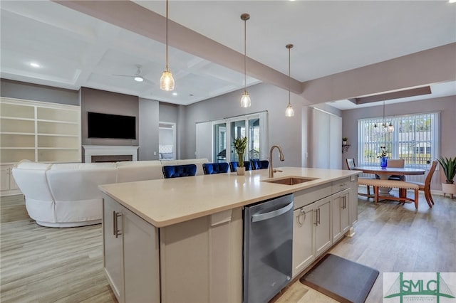 kitchen featuring dishwasher, hanging light fixtures, and a kitchen island with sink