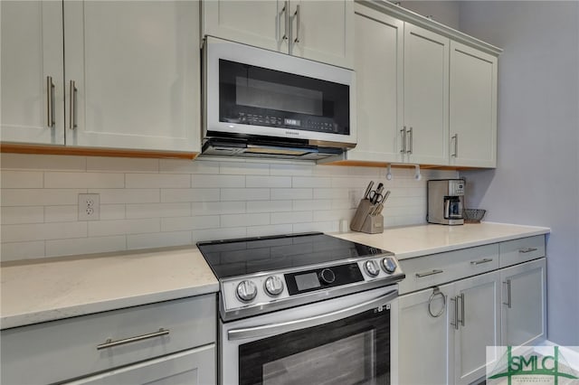 kitchen with appliances with stainless steel finishes and tasteful backsplash