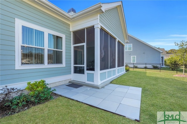 view of home's exterior with a sunroom and a yard