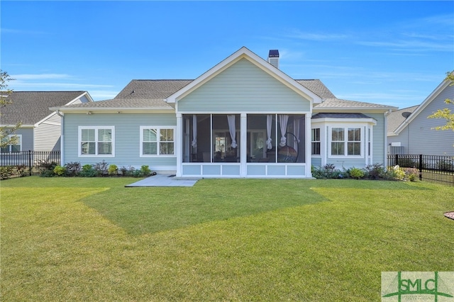 back of property featuring a sunroom and a yard