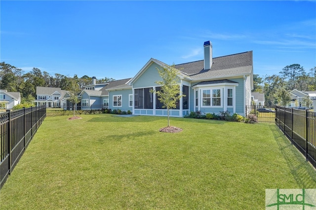 rear view of house featuring a sunroom and a yard