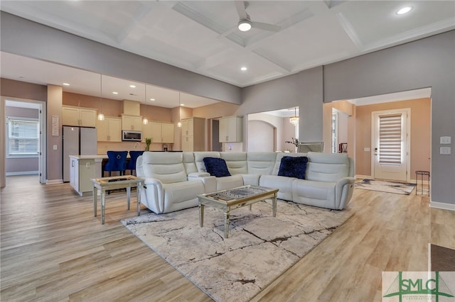 living room with light hardwood / wood-style floors, beamed ceiling, ceiling fan, and coffered ceiling