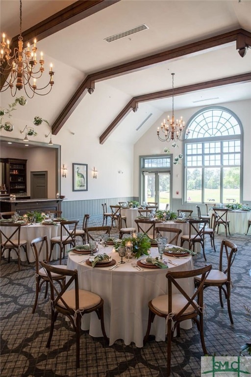 dining space with high vaulted ceiling, an inviting chandelier, and beam ceiling