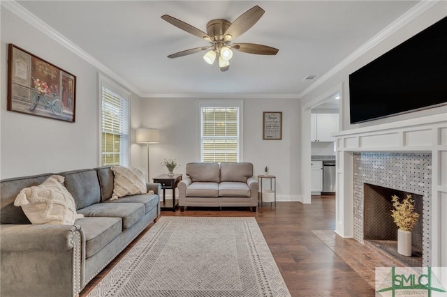 living room with a fireplace, dark hardwood / wood-style flooring, ceiling fan, and ornamental molding