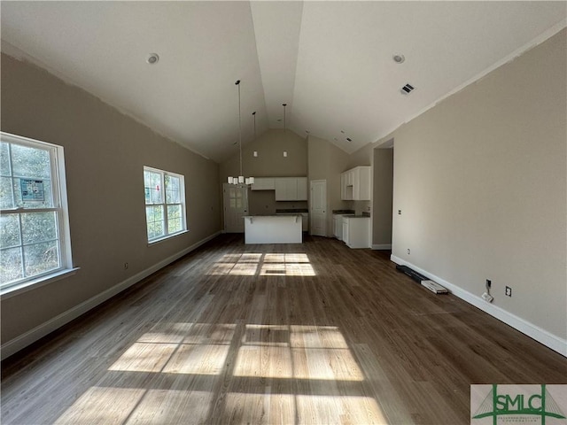 unfurnished living room featuring dark hardwood / wood-style floors and vaulted ceiling