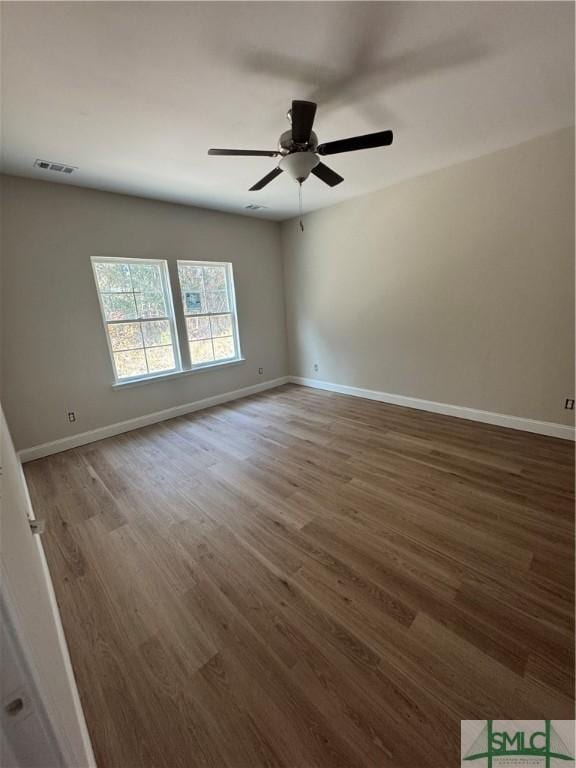 unfurnished room featuring ceiling fan and dark hardwood / wood-style flooring