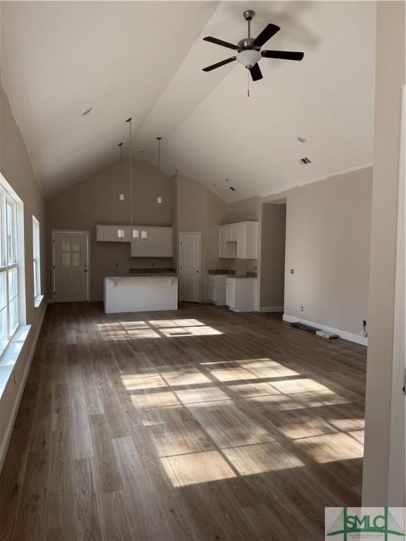 unfurnished living room featuring ceiling fan, dark hardwood / wood-style flooring, and high vaulted ceiling