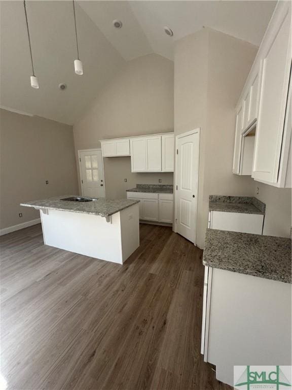 kitchen featuring decorative light fixtures, dark hardwood / wood-style flooring, white cabinetry, and high vaulted ceiling