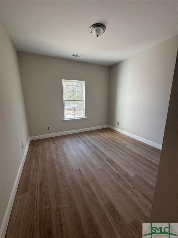 spare room with dark hardwood / wood-style flooring