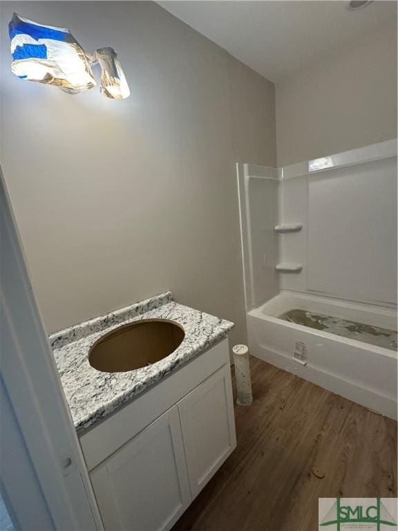 bathroom featuring shower / bathing tub combination, wood-type flooring, and vanity