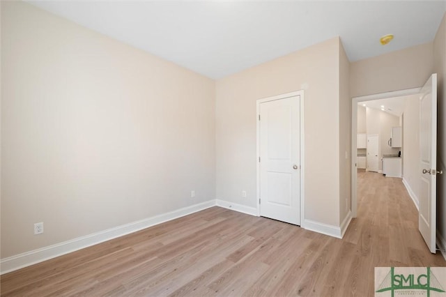 unfurnished bedroom featuring light wood-type flooring and baseboards