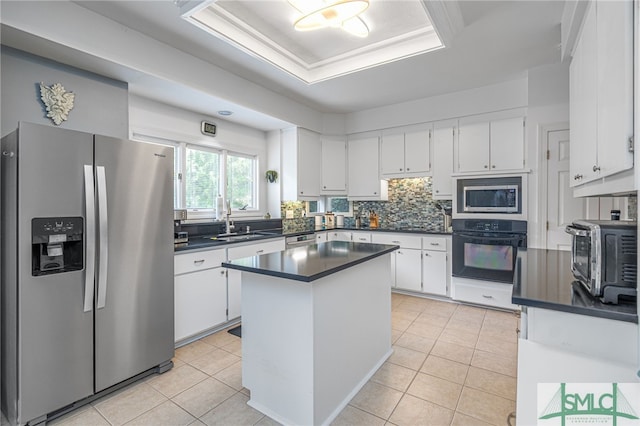 kitchen featuring a kitchen island, white cabinetry, appliances with stainless steel finishes, and light tile patterned floors