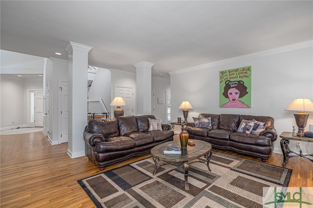 living room with light hardwood / wood-style floors, crown molding, and decorative columns