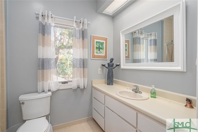 bathroom with toilet, vanity, and tile patterned floors