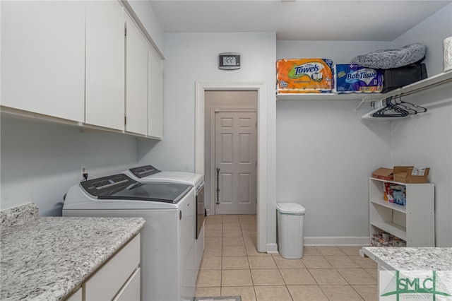 laundry room featuring cabinets, light tile patterned flooring, and separate washer and dryer