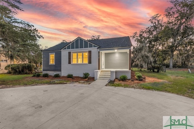 view of front of property with a garage and a lawn